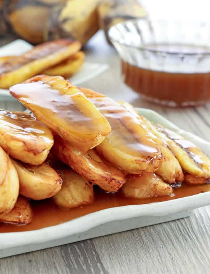 fried saba bananas with latik sauce in a white serving platter